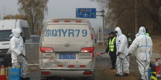 Workers disinfect a passing vehicle after the latest incident of African swine flu outbreak on the outskirts of Beijing, China, Nov. 23, 2018 (AP photo by Ng Han Guan).