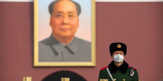 A paramilitary policeman wears a face mask as he stands guard near the large portrait of Chinese leader Mao Zedong at Tiananmen Gate in Beijing, Jan. 27, 2020 (AP photo by Mark Schiefelbein).