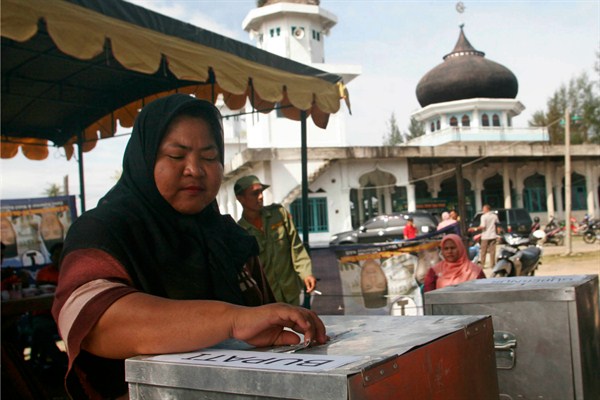 A woman casts her ballot at a voting station during a local election in Aceh Besar, Aceh province, Indonesia, April 9, 2012 (AP photo by Heri Juanda).