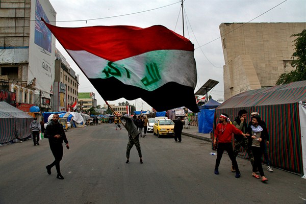 A man waves an Iraqi flag during anti-government demonstrations in Tahrir Square, Baghdad, Iraq, Feb. 9, 2020 (AP photo by Khalid Mohammed).