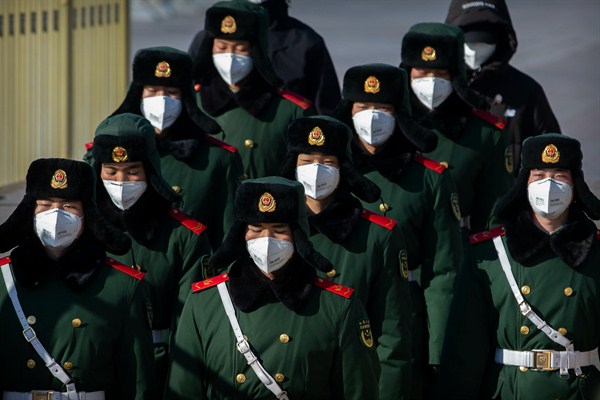 Paramilitary policemen wear face masks as they march in formation near Tiananmen Square, Beijing, Feb. 4, 2020 (AP photo by Mark Schiefelbein).