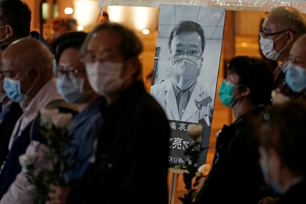 People wearing masks attend a vigil for Chinese doctor Li Wenliang, in Hong Kong, Feb. 7, 2020 (AP photo by Kin Cheung).