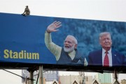 A monkey sits on a billboard welcoming President Donald Trump ahead of his visit to Ahmedabad, India, Feb. 19, 2020 (AP photo by Ajit Solanki).