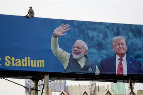 A monkey sits on a billboard welcoming President Donald Trump ahead of his visit to Ahmedabad, India, Feb. 19, 2020 (AP photo by Ajit Solanki).