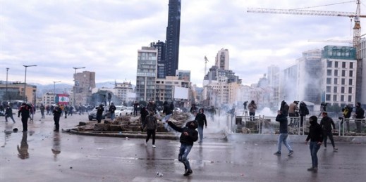 Anti-government demonstrators throw tear gas canisters back at riot police on a road leading to the parliament building during a protest in downtown Beirut, Lebanon, Feb. 11, 2020 (AP photo by Bilal Hussein).