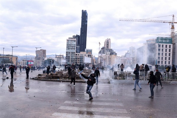 Anti-government demonstrators throw tear gas canisters back at riot police on a road leading to the parliament building during a protest in downtown Beirut, Lebanon, Feb. 11, 2020 (AP photo by Bilal Hussein).
