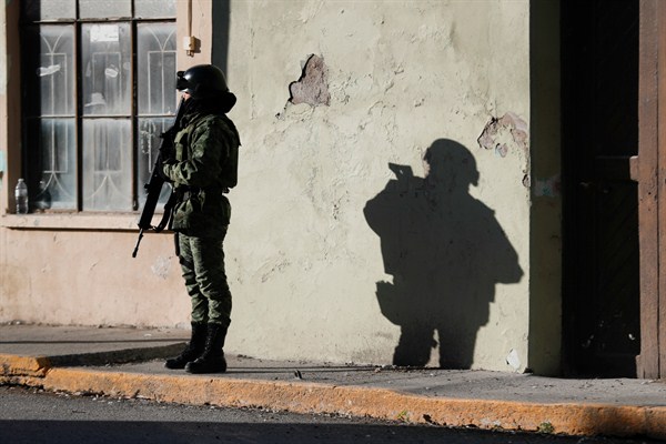 A member of the Mexican security forces stands guard near City Hall in Villa Union, an area previously patrolled by Mexican marines until President Andres Manuel Lopez Obrador reassigned them to other duties, Dec. 3, 2019. (AP photo by Eduardo Verdugo).