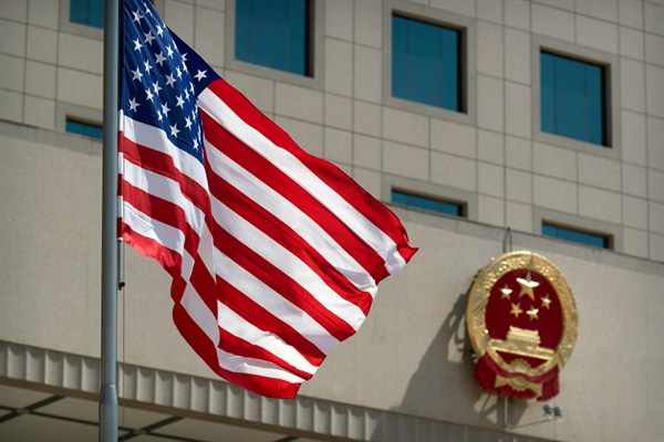 The American flag flies near the national emblem of China outside the Bayi Building in Beijing, Nov. 9, 2017 (AP photo by Andy Wong).