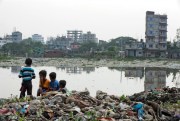 Bangladeshi children sit on garbage piled up by the Buriganga River in Dhaka, Bangladesh, June 4, 2018 (AP photo by A.M. Ahad).