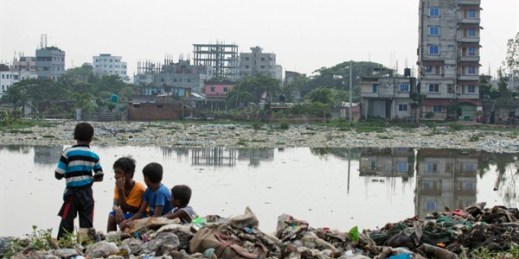 Bangladeshi children sit on garbage piled up by the Buriganga River in Dhaka, Bangladesh, June 4, 2018 (AP photo by A.M. Ahad).
