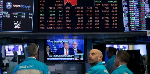 Traders at the New York Stock Exchange watch President Donald Trump’s televised White House news conference, March 18, 2020 (AP photo by Mark Lennihan).