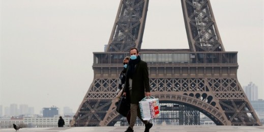 A masked couple walks on the empty Trocadero next to the Eiffel Tower, in Paris, March 17, 2020 (AP photo by Francois Mori).