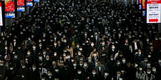 A large crowd wearing masks commutes through Shinagawa Station in Tokyo, Japan, Mar. 3, 2020 (AP photo by Jae C. Hong).