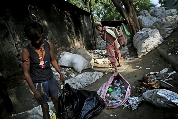 Trash collectors pick up plastic bottles in New Delhi, India, Sept. 26, 2019 (AP photo by Altaf Qadri).