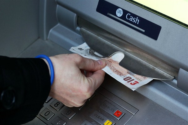 A cash withdrawal at an ATM in Macclesfield, England (Photo by Lynne Cameron for Press Association via AP Images).