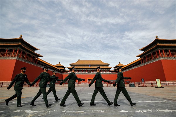 Chinese soldiers wearing protective face masks outside the gates to the Forbidden City, Beijing, March 12, 2020 (AP photo by Andy Wong).