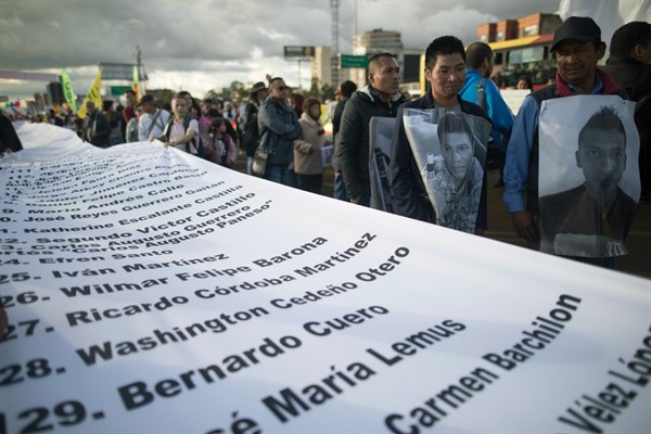 Demonstrators hold a banner with the names of murdered activists during a protest march in Bogota, Colombia, July 26, 2019 (AP photo by Ivan Valencia).
