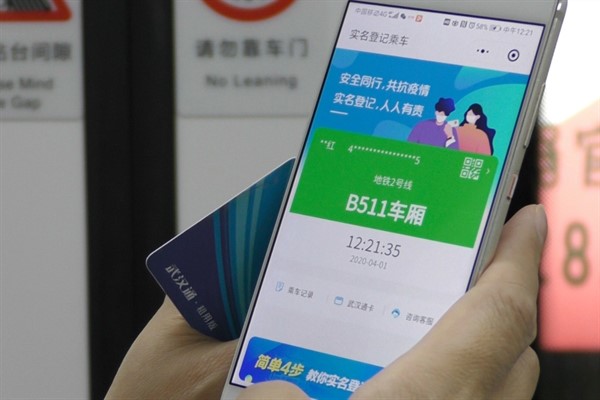 A subway passenger holds up a green code on their phone, which allows a person to travel freely, in Wuhan, China, April 1, 2020 (AP photo by Olivia Zhang).
