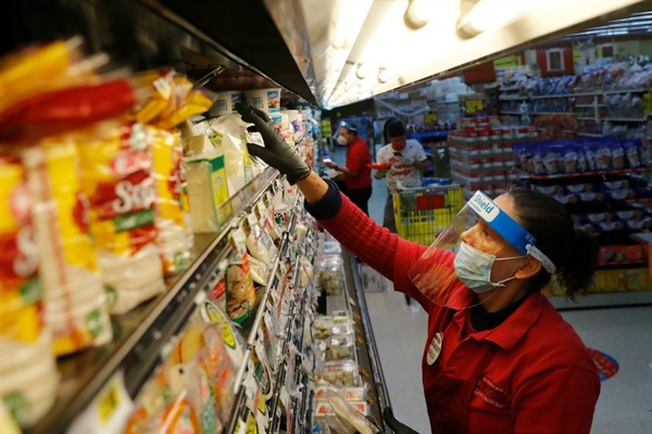 A grocery store worker restocks shelves, Dallas, Texas, April 13, 2020 (AP photo by LM Otero).