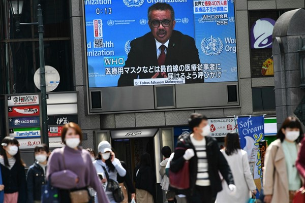 A monitor shows World Health Organization Director-General Tedros Adhanom Ghebreyesus, in Osaka, Japan, March 26, 2020 (Photo by Taketo Oishi for the Yomiuri Shimbun via AP Images).