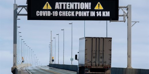 A sign indicates a COVID-19 checkpoint ahead as a truck crosses the Confederation Bridge in Cape Jourimain, New Brunswick, Canada, March 22, 2020 (photo by Andrew Vaughan for The Canadian Press via AP).