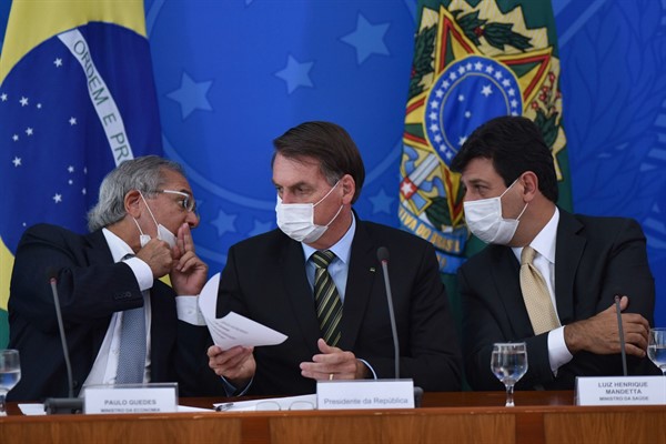 President Jair Bolsonaro, center, with the economy minister and health minister during a press conference on the coronavirus, Brasilia, Brazil, March 18, 2020 (AP photo by Andre Borges).