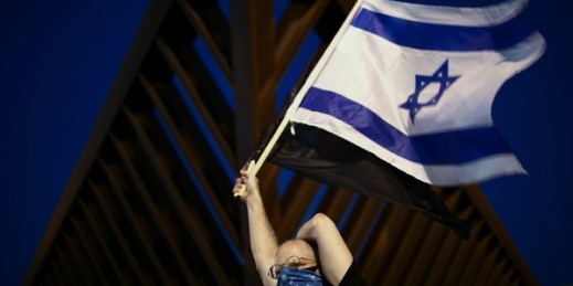 A protester waves the Israeli national flag during a demonstration against Prime Minister Benjamin Netanyahu, Tel Aviv, Israel, April 19, 2020 (AP photo by Oded Balilty).