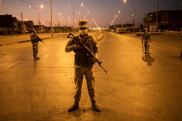 Soldiers stand guard after the start of a curfew to slow the spread of the coronavirus, in Lima, Peru, April 22, 2020 (AP photo by Rodrigo Abd).