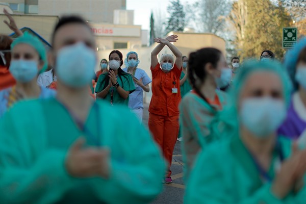 Health workers react as people applaud from their houses in Madrid, April 1, 2020 (AP photo by Manu Fernandez).
