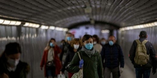 Passengers wearing face masks in a metro station tunnel in Barcelona, Spain, April 15, 2020 (AP photo by Emilio Morenatti).