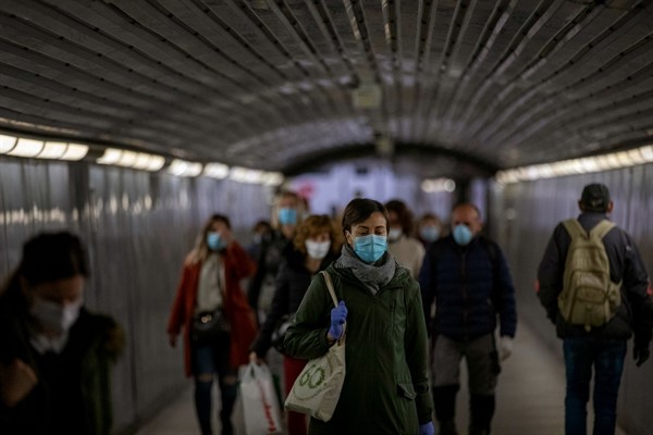 Passengers wearing face masks in a metro station tunnel in Barcelona, Spain, April 15, 2020 (AP photo by Emilio Morenatti).
