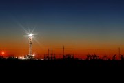 An oil rig lights up the horizon after a late sunset on the outskirts of Midland, Texas, April 2, 2020 (Photo by Eli Hartman for Odessa American via AP Images).
