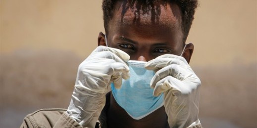 A man wearing a surgical mask and gloves in Mogadishu, Somalia, March 18, 2020 (AP photo by Farah Abdi Warsameh).