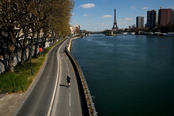 A man jogs on an empty street along the Seine river in Paris, France, April 4, 2020 (AP photo by Christophe Ena).