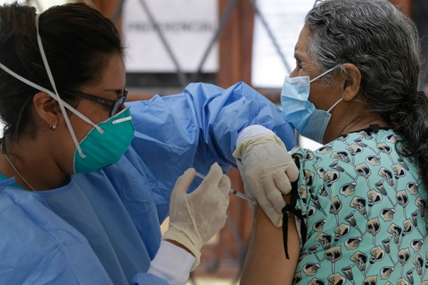 A nurse injects an elderly woman with an influenza vaccine in Lima, Peru, March 17, 2020 (AP photo by Martin Mejia).
