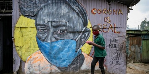 A boy wearing a mask walks past a mural warning people about the coronavirus, Nairobi, Kenya, April 18, 2020 (AP photo by Brian Inganga).