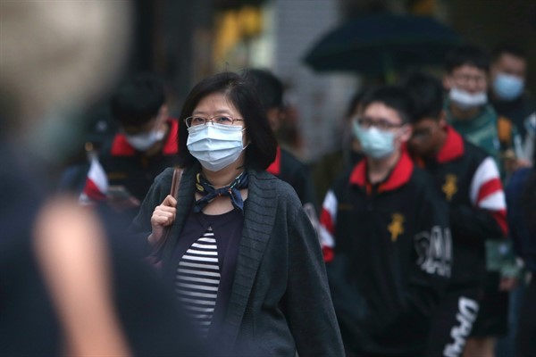 People wear face masks to protect against the coronavirus on a street in Taipei, Taiwan, March 30, 2020 (AP photo by Chiang Ying-ying).