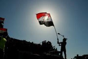 A protester holds an Iraqi flag during anti-government protests in Baghdad, Iraq, May 12, 2020 (AP photo by Hadi Mizban).