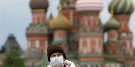 A woman walks near Red Square with St. Basil’s Cathedral in the background, in Moscow, Russia, May 12, 2020 (AP photo by Alexander Zemlianichenko).