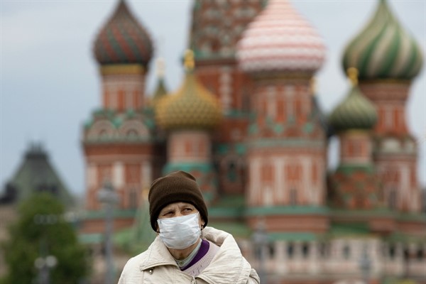 A woman walks near Red Square with St. Basil’s Cathedral in the background, in Moscow, Russia, May 12, 2020 (AP photo by Alexander Zemlianichenko).