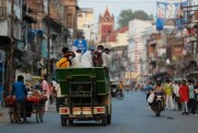 People wearing masks ride a mini truck in Prayagraj, India, May 23, 2020 (AP photo by Rajesh Kumar Singh).