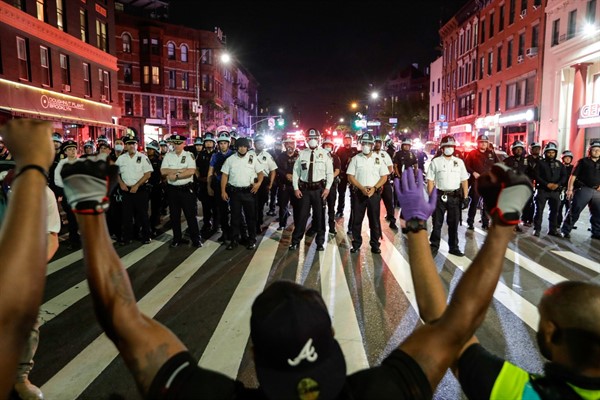 Protesters take a knee in front of New York City police officers during a demonstration in Brooklyn, New York, June 4, 2020 (AP photo by Frank Franklin II).