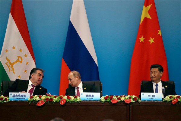 Russian President Vladimir Putin, center, speaks with Tajikistan President Emomali Rahmon, left, next to Chinese leader Xi Jinping right, during a summit in Qingdao, China, June 10, 2018 (AP photo by Dake Kang).