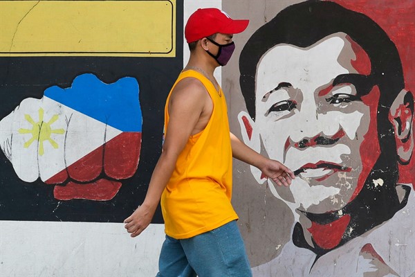 A man walks past an image of Philippine President Rodrigo Duterte in Manila, Philippines, March 20, 2020 (AP photo by Aaron Favila).