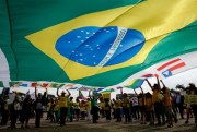 Demonstrators hold a Brazilian flag to support Operation Car Wash and former judge Sergio Moro, in front of Supreme Court headquarters in Brasilia, Brazil, Sept. 25, 2019 (AP photo by Eraldo Peres).