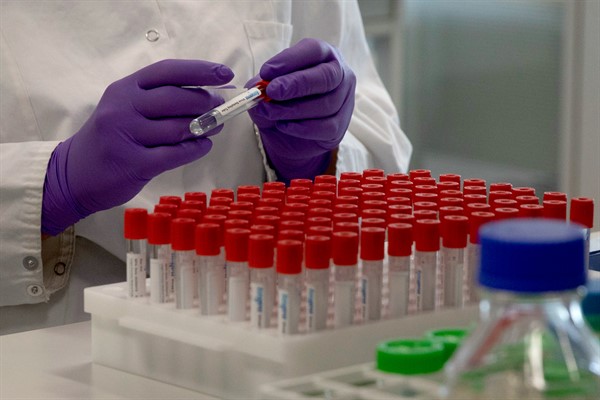 A lab technician puts labels on test tubes during research on COVID-19 at Janssen Pharmaceutical, a Johnson & Johnson subsidiary, in Beerse, Belgium, June 17, 2020 (AP photo by Virginia Mayo).