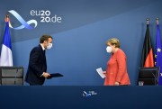 German Chancellor Angela Merkel, right, and French President Emmanuel Macron prepare to address the media at the end of an EU summit in Brussels, July 21, 2020 (AFP pool photo by John Thys via AP Images).