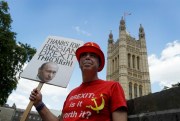 Anti-Brexit campaigner Steve Bray holds up a sign showing Vladimir Putin’s face outside Parliament in London, July 21, 2020 (AP photo by Kirsty Wigglesworth).
