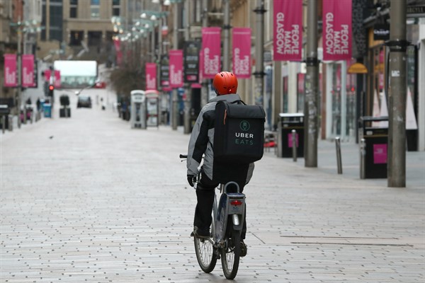 An Uber Eats cyclist during the coronavirus pandemic shutdown in Glasgow, Scotland, March 28, 2020 (Photo by Andrew Milligan for Press Association via AP Images).