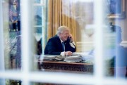 President Donald Trump speaks on the phone with German Chancellor Angela Merkel in the Oval Office of the White House, in Washington, Jan. 28, 2017 (AP photo by Andrew Harnik).